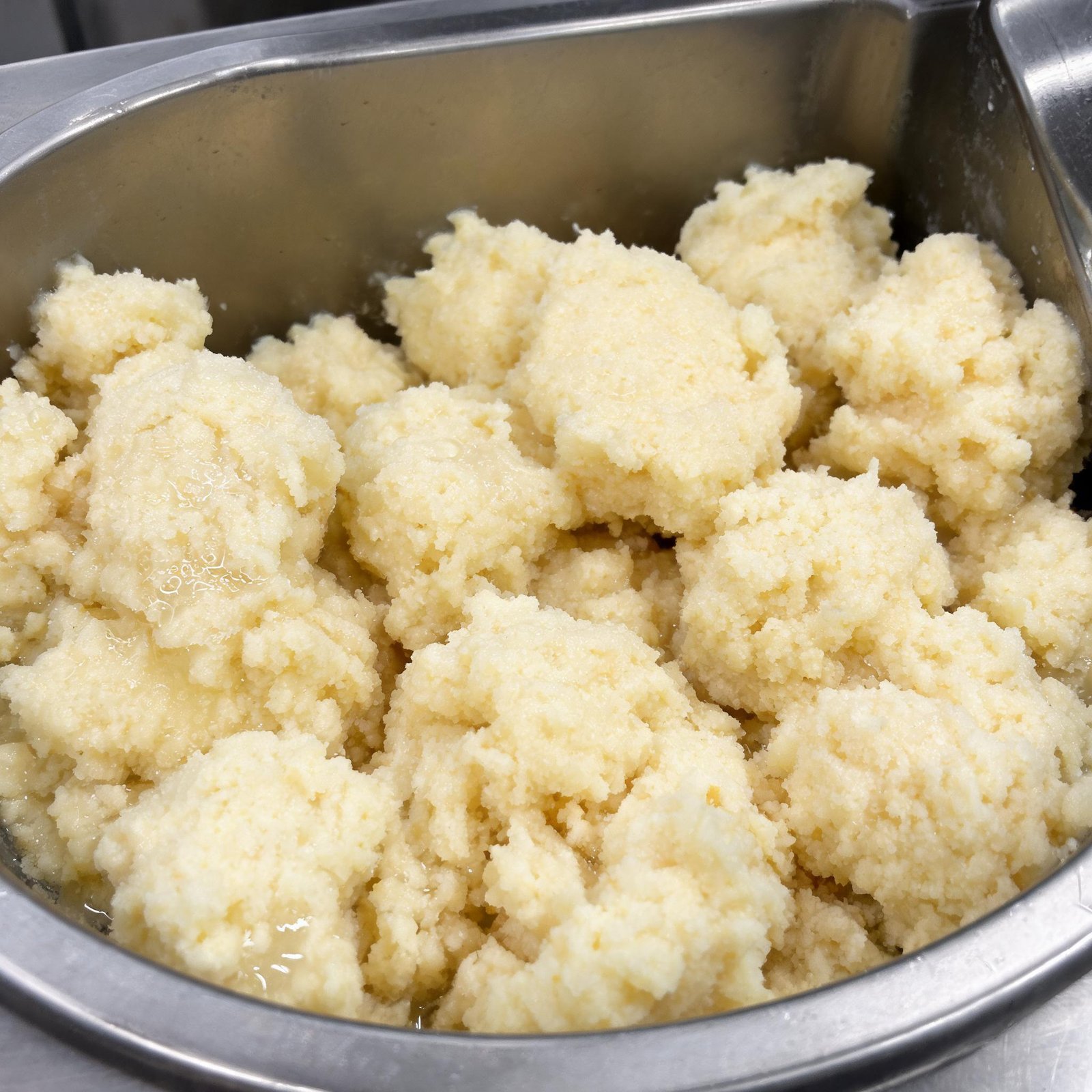 close up of hydrated semolina curds in a mixing trough